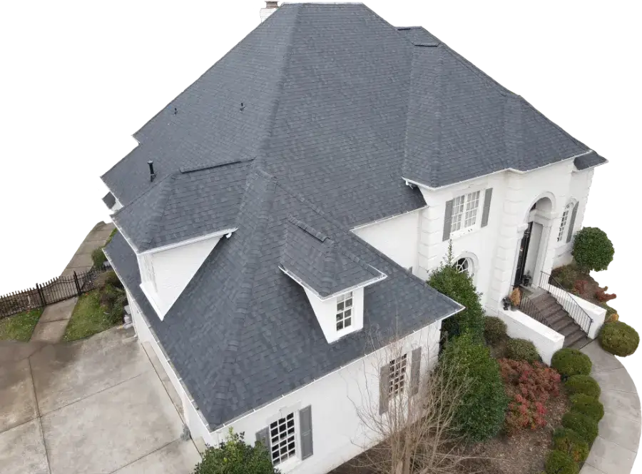 A dark gray asphalt shingle roof covers this white colonial-style house, with a brick chimney, arched entryway, and dormer windows.